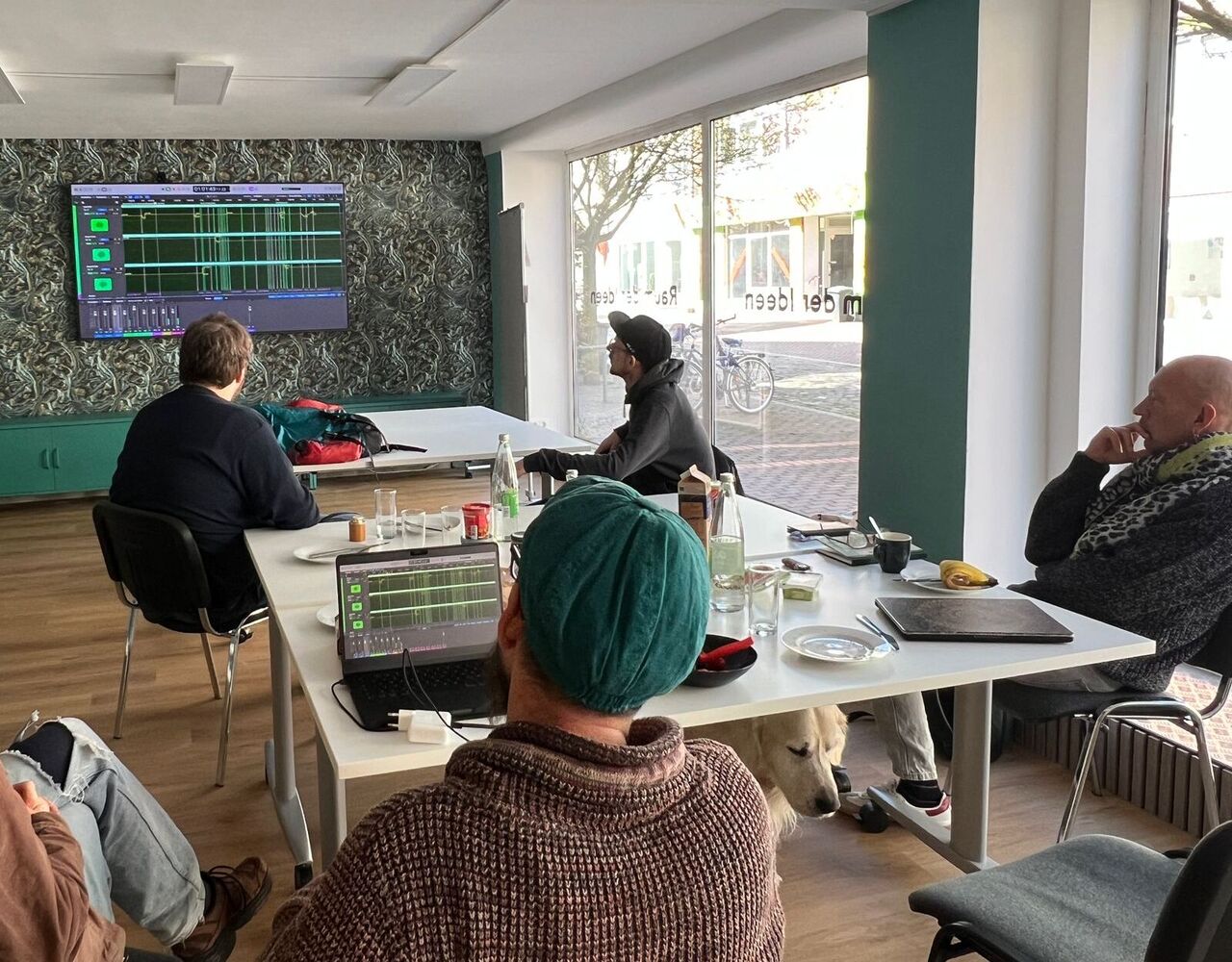 Mitarbeiter des Projekts sehen sich Audiodateien auf einem Smartscreen an